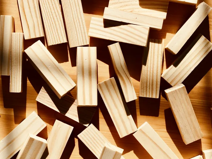 Wooden building blocks scattered across a wooden surface