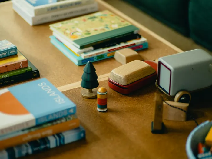 Picture books and wooden toys stacked on a wooden table