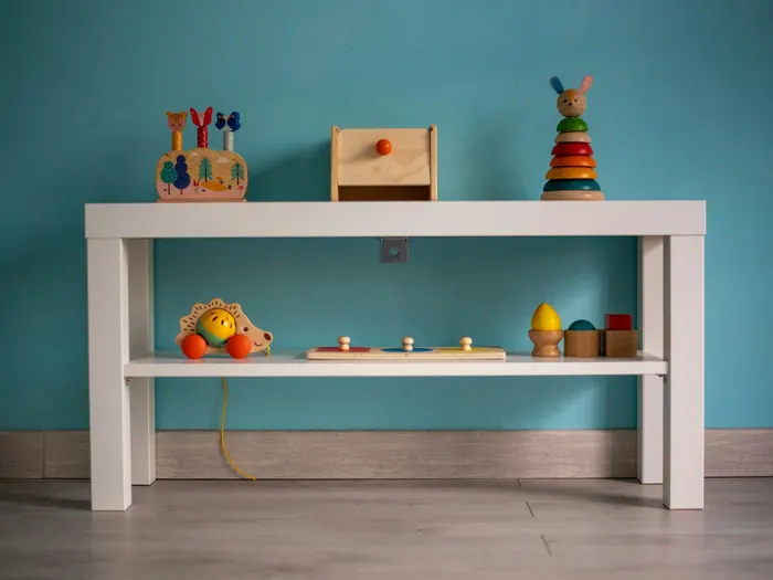 A small white table with wooden toys arranged on it